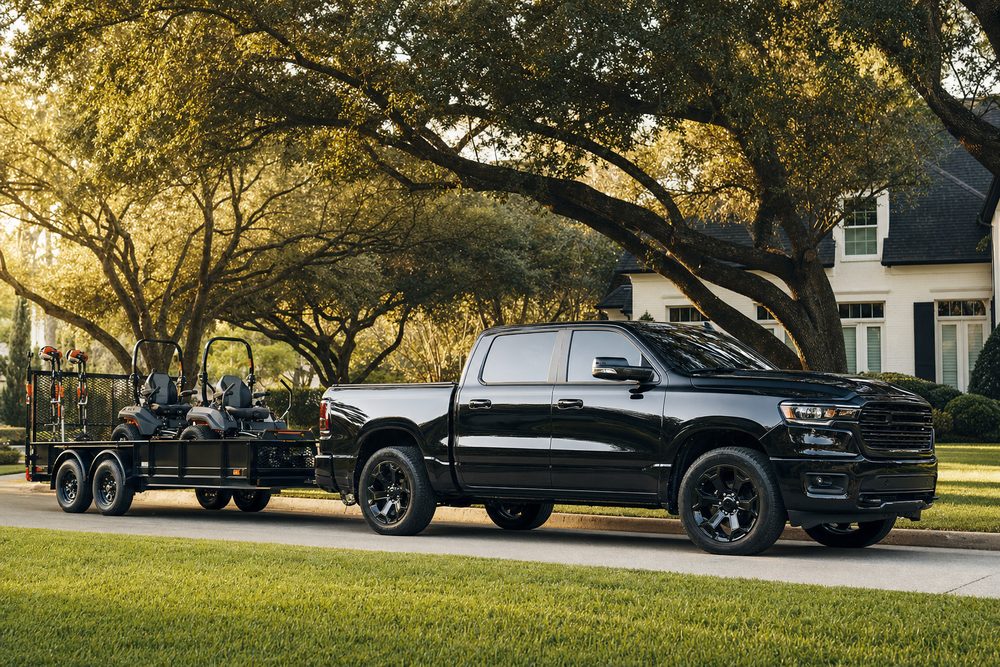 Black Southbound Landscape Co. truck and enclosed trailer loaded with commercial mowers
